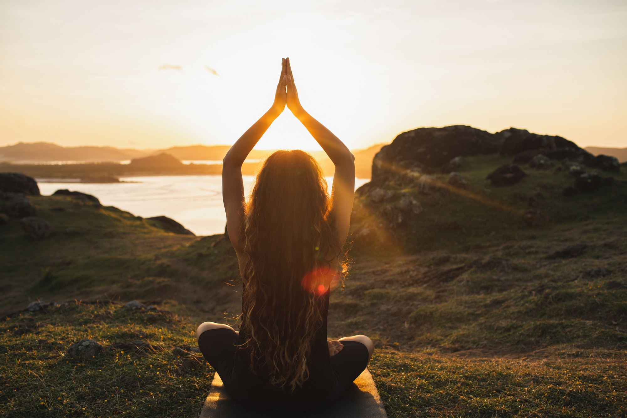 Young woman practicing yoga outdoors. Spiritual harmony, introspection and well-being concept